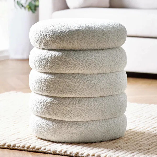 Stack of textured round cushions on a rug in a living room setting