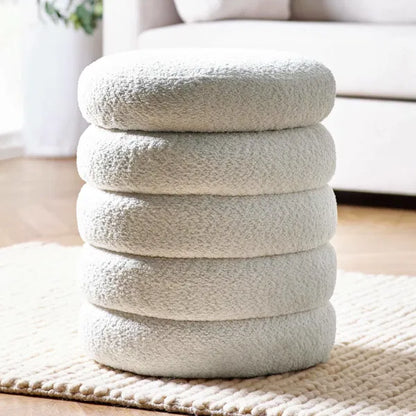 Stack of textured round cushions on a rug in a living room setting